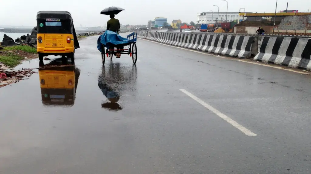 Wet Indian street with auto rickshaw reflections in monsoon rain