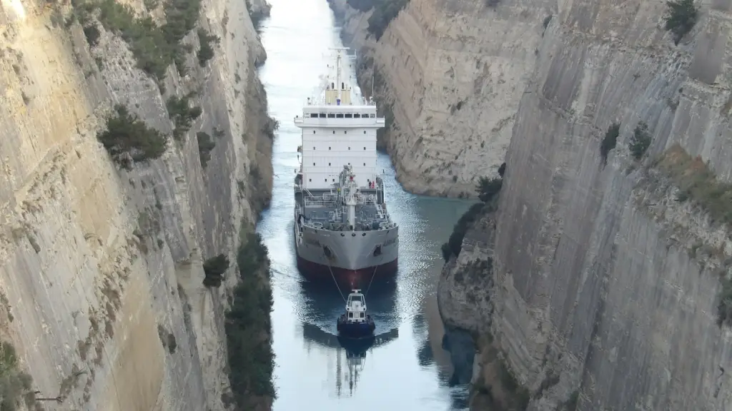 Large cargo ship navigating a narrow waterway between rocky walls