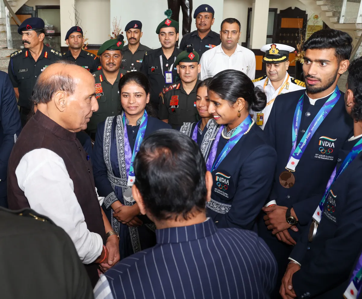 The defence minister speaks with athletes after the ceremony