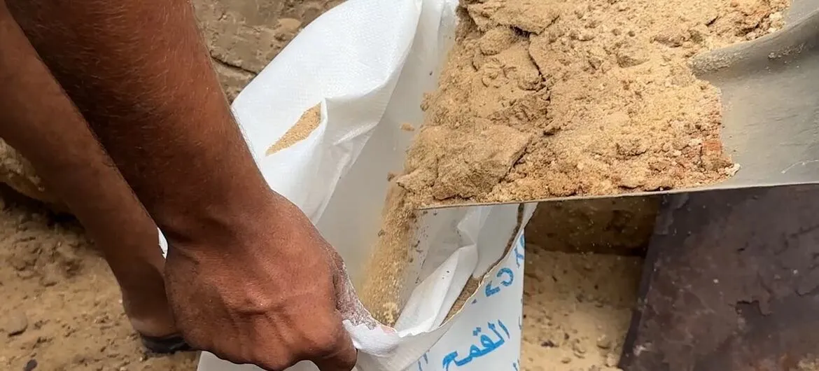 Gaza winter: Displaced people in Gaza fill flour sacks with sand around their tents to keep rainwater out