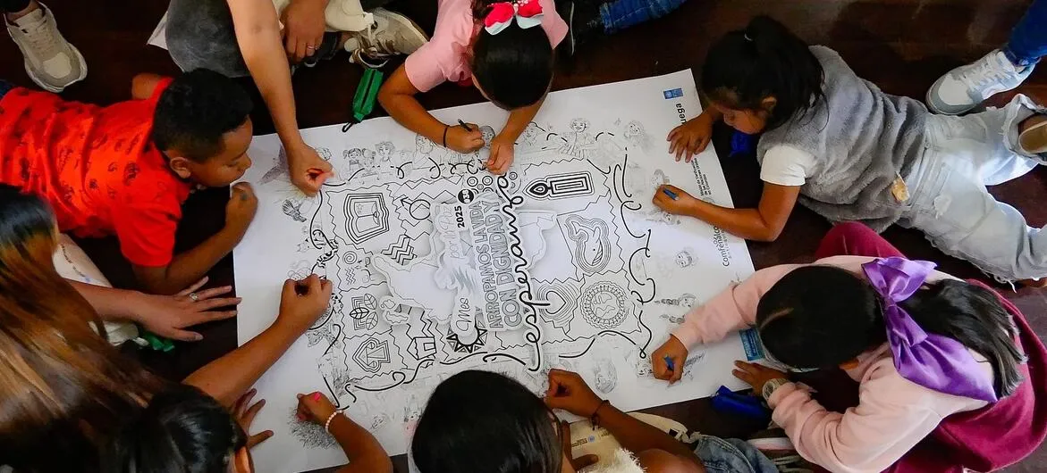Colombia peace deal: Children colour a map of Colombia at a UN Verification Mission peace event